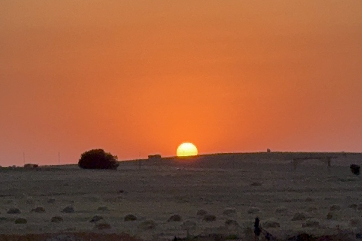 sun setting over the horizon in Yntymaq, Kazakhstan